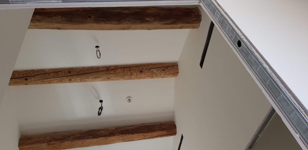 Plafond refait entre des poutres anciennes conservées apparentes